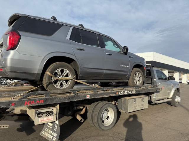 Activate Towing flatbed transporting a Chevrolet Tahoe SUV in the Parker, CO area