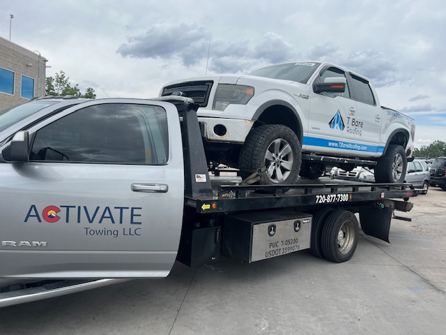 Activate Towing flatbed recovering a Ford F-150 contractor work truck in Douglas County