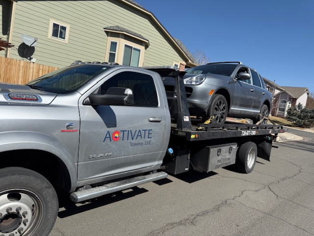 Activate Towing flatbed loading a Porsche Cayenne SUV from a residential driveway